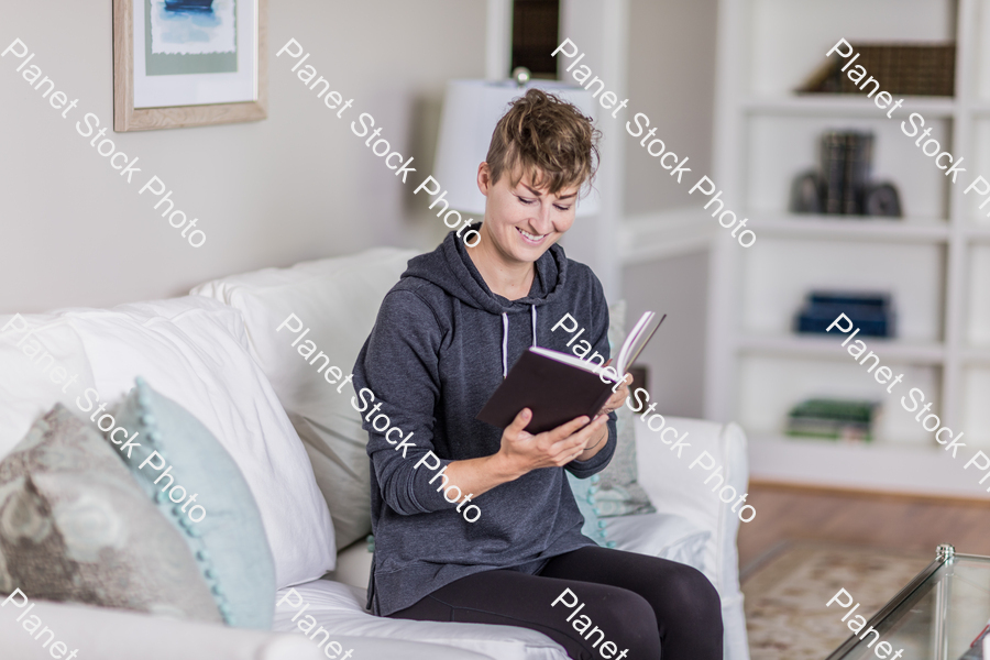 A young lady sitting on the couch stock photo with image ID: 0177902f-7377-4479-b181-3427397aabdb