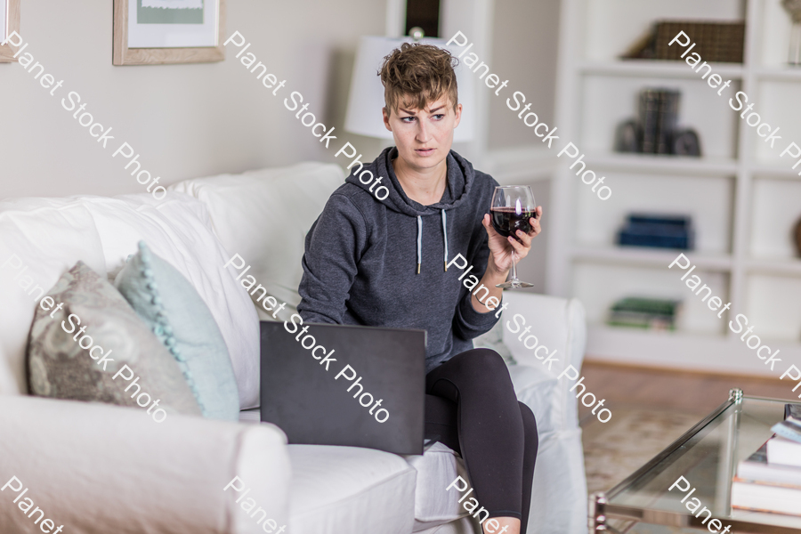 A young lady sitting on the couch stock photo with image ID: 03356cee-6604-4c05-98f5-c46440ab249f