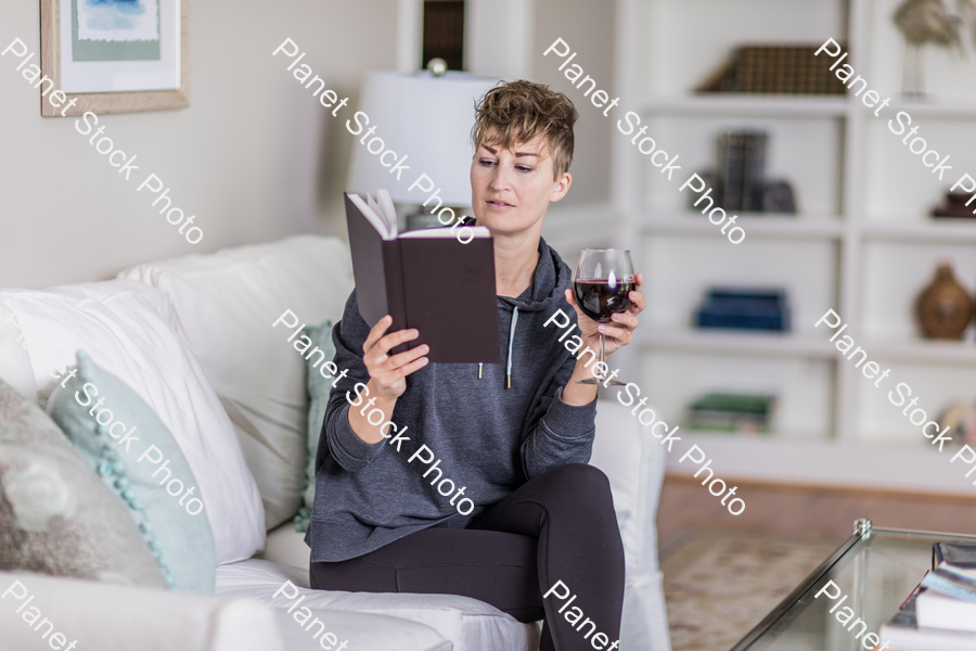 A young lady sitting on the couch stock photo with image ID: 04bcf5fe-23ce-4912-bc15-32337a4a6841