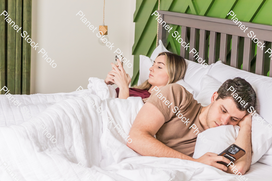 A young couple lying in bed stock photo with image ID: 04e80db8-e774-43d9-8bb8-e75da16356d8