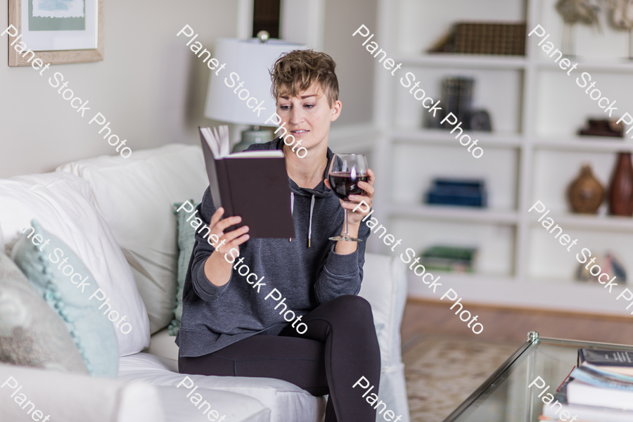 A young lady sitting on the couch stock photo with image ID: 054d7976-d69e-4f13-8f2a-c7e1d1e6cbbb