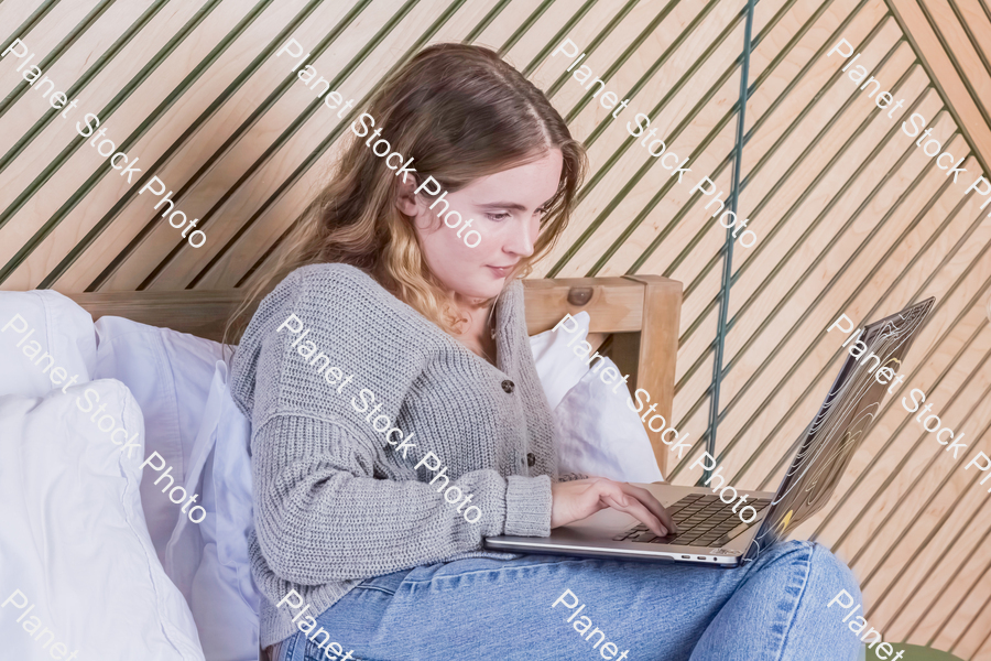 A girl using a laptop in bed stock photo with image ID: 0f0c2528-d8dd-40b4-8136-794acb744bed