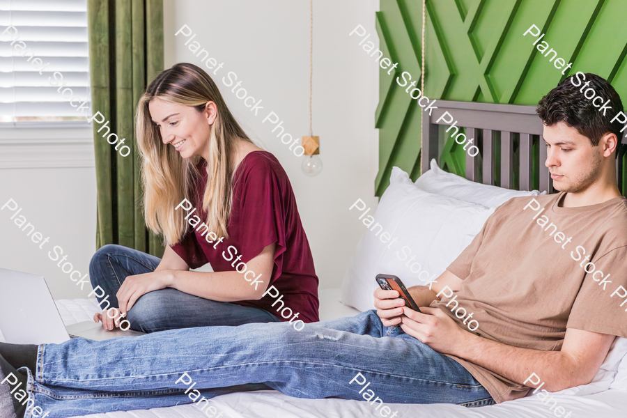 A young couple sitting in bed stock photo with image ID: 1187dc0e-5633-4cd3-9dd1-66bee17572f9