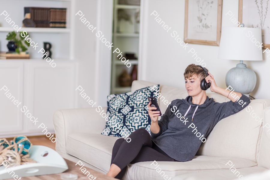 A young lady sitting on the couch stock photo with image ID: 14770de0-0a13-46eb-819e-a10dac3ec615