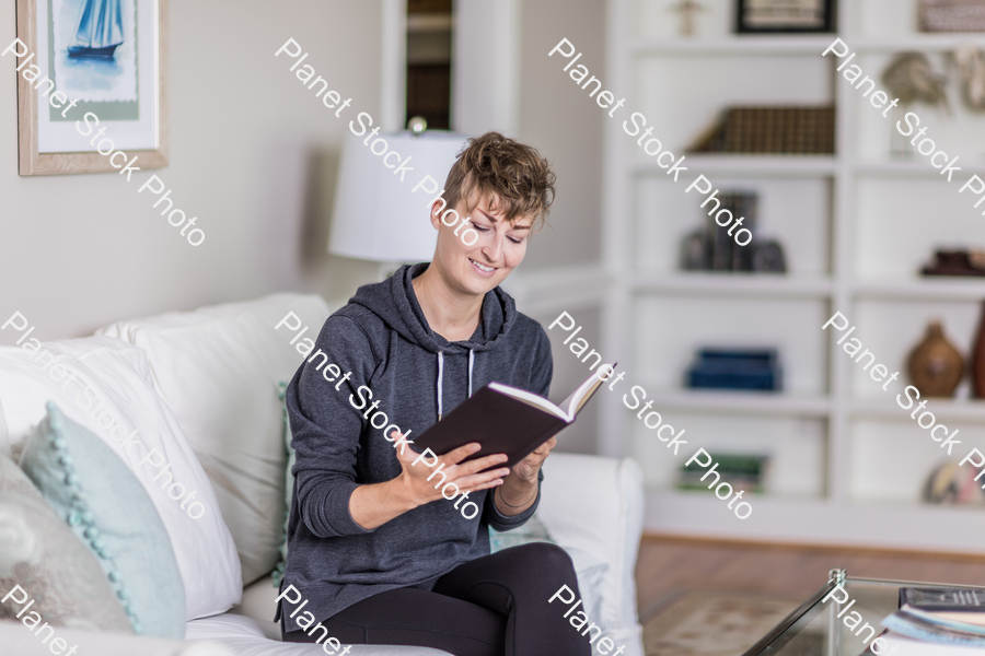 A young lady sitting on the couch stock photo with image ID: 1585d6f0-d222-4d95-b933-e74651ed326d