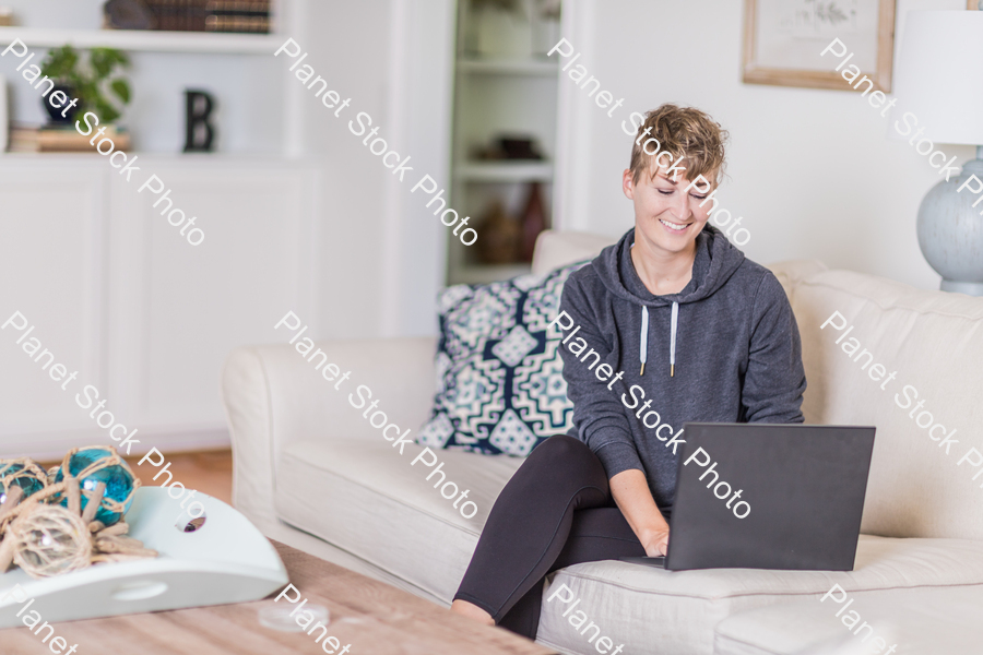 A young lady sitting on the couch stock photo with image ID: 180a02cd-3d3c-474e-b91f-7255464cf5f3