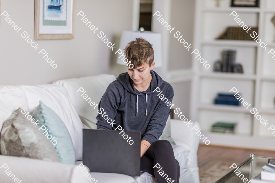 A young lady sitting on the couch stock photo with image ID: 1b75ead6-5256-47c0-ae4f-aaf53c9a8b30