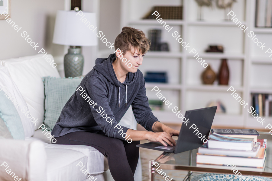 A young lady sitting on the couch stock photo with image ID: 211b4dc6-607e-4766-a6dc-2d8d878cbd85