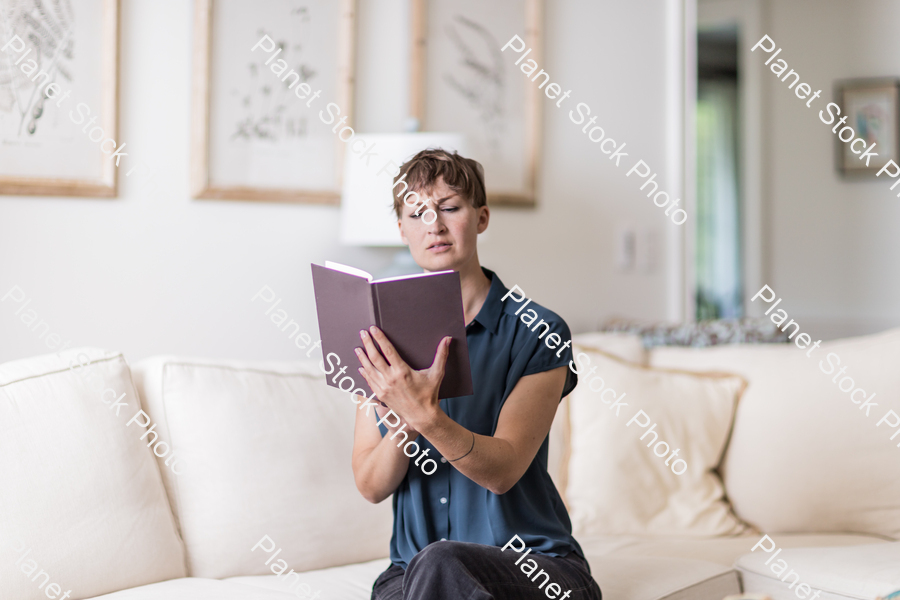 A young lady sitting on the couch stock photo with image ID: 21727e14-4f8e-4423-a8e7-d564da25f160