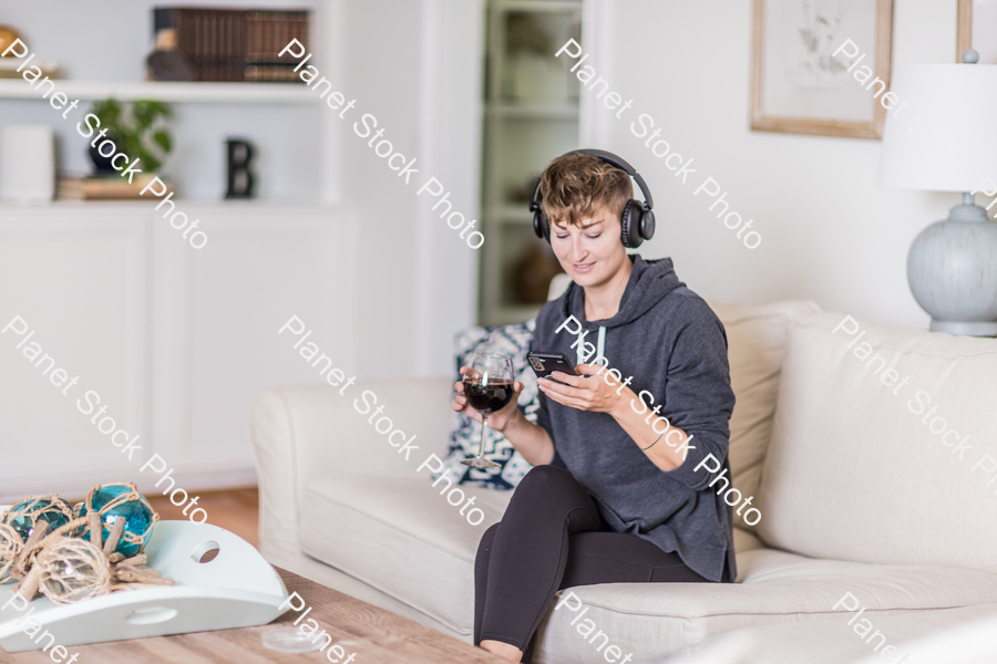 A young lady sitting on the couch stock photo with image ID: 219183e9-382f-4ec6-a191-25094651cf22