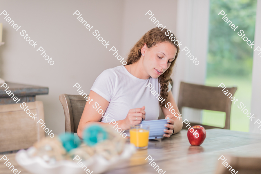 A young lady having a healthy breakfast stock photo with image ID: 24ed05d2-7601-4e79-9940-ec9ed6ccda3c