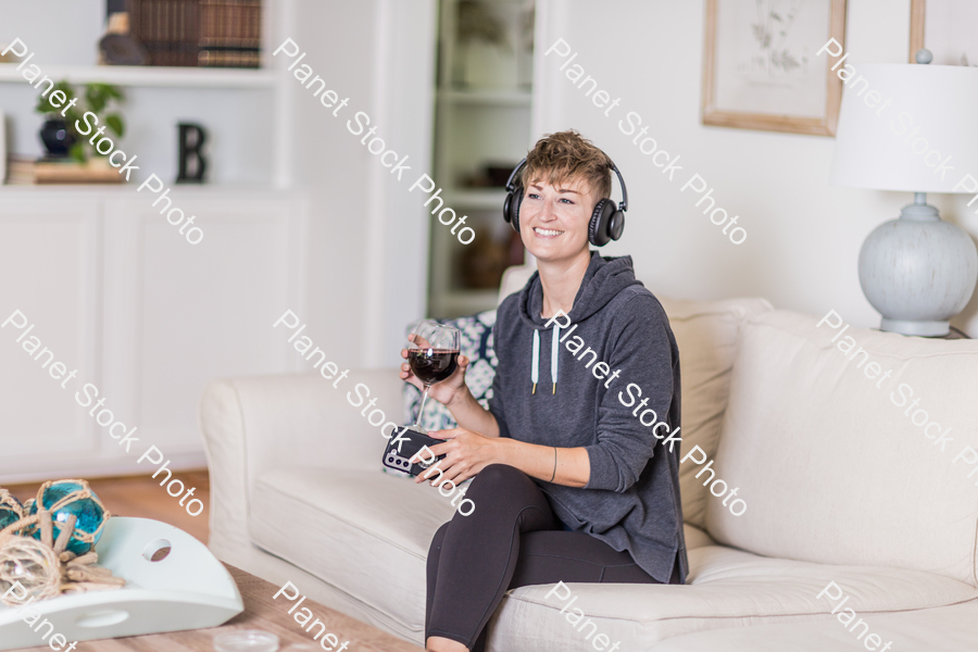 A young lady sitting on the couch stock photo with image ID: 26dc54ec-6af3-4c13-ae1f-61a21f70fbb6