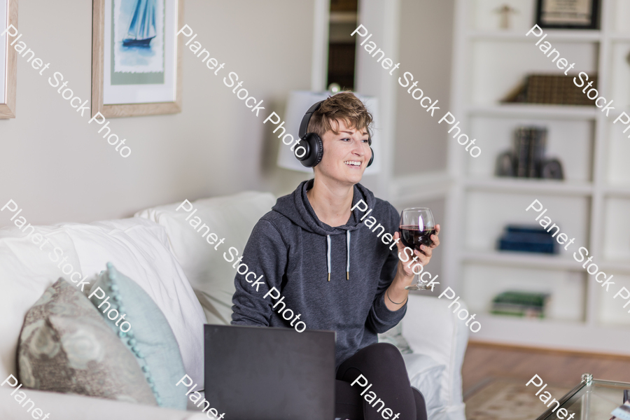 A young lady sitting on the couch stock photo with image ID: 27f335d3-587d-41a3-9535-24d5eeed8def