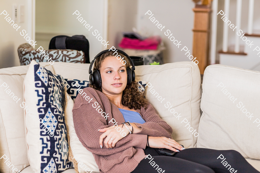 A young lady sitting on the couch stock photo with image ID: 3173c25e-3243-492f-879f-28b2d45399eb