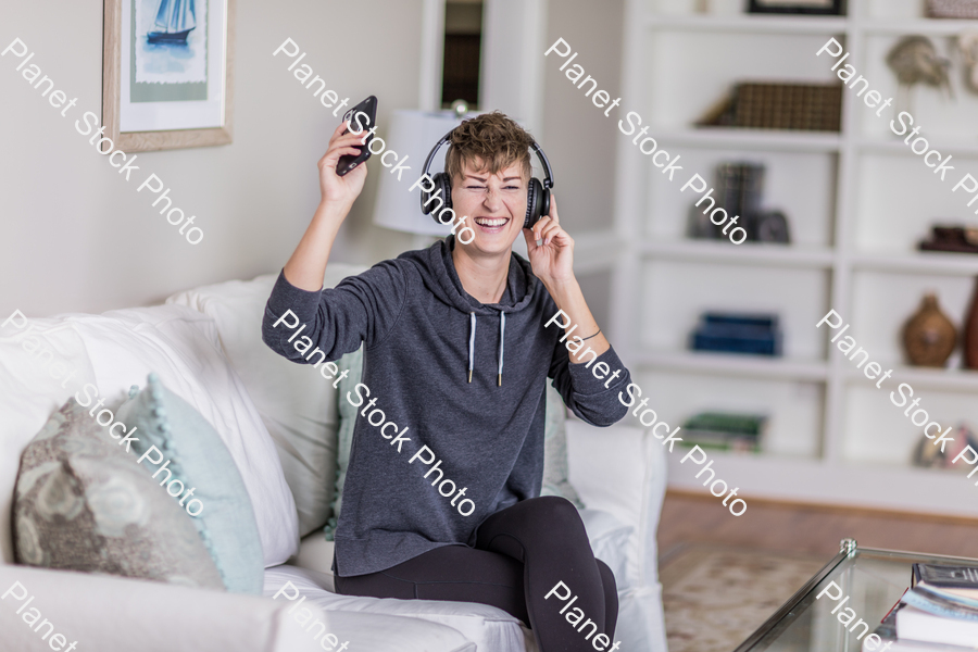 A young lady sitting on the couch stock photo with image ID: 33043399-023d-4002-9d02-afed978a5055