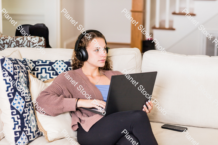 A young lady sitting on the couch stock photo with image ID: 380e55e3-d6a4-4649-bc40-6c29b172b8ef