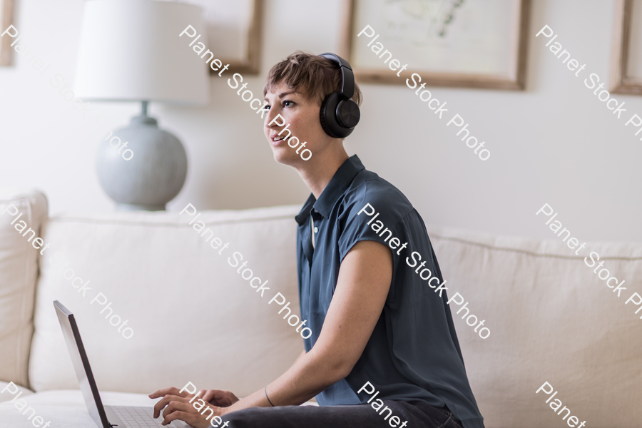 A young lady sitting on the couch stock photo with image ID: 39f7dc57-1b42-4570-97b9-966e7cb52a3a