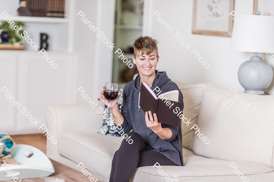 A young lady sitting on the couch stock photo with image ID: 40bdc025-e2bf-4717-a551-fb4fbb585643