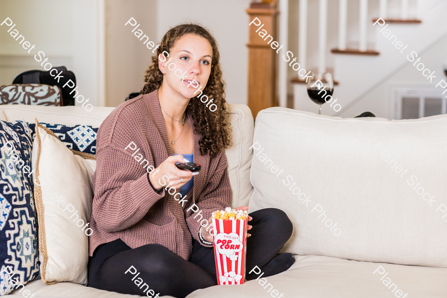 A young lady sitting on the couch stock photo with image ID: 40f4298a-d687-4fa0-be53-e73af0858616