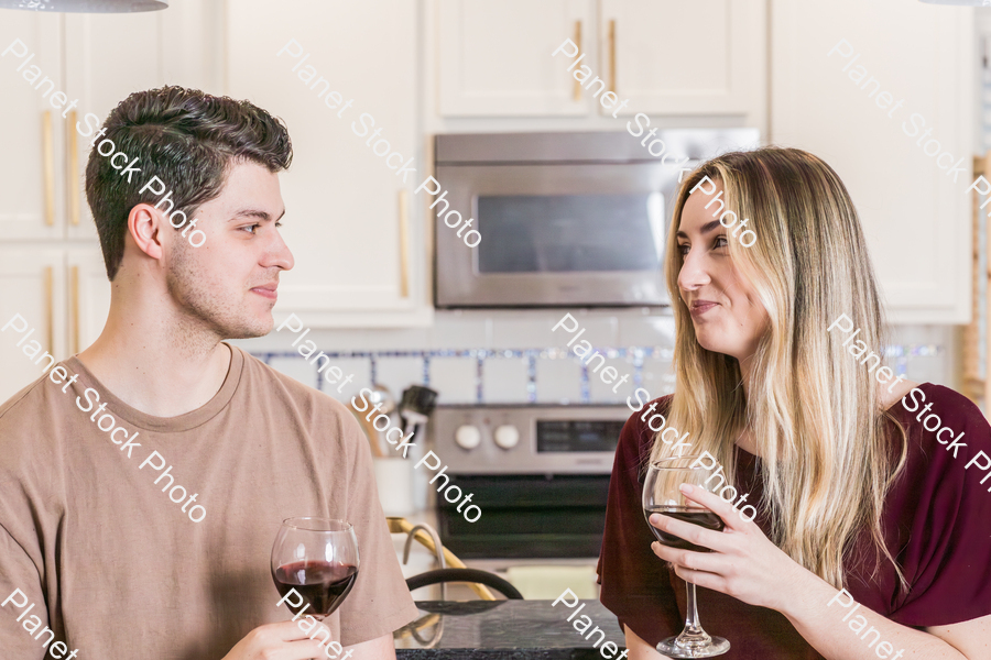 A young couple sitting and enjoying red wine stock photo with image ID: 42e4735b-02ff-4c9c-a35e-9e96be5066ce