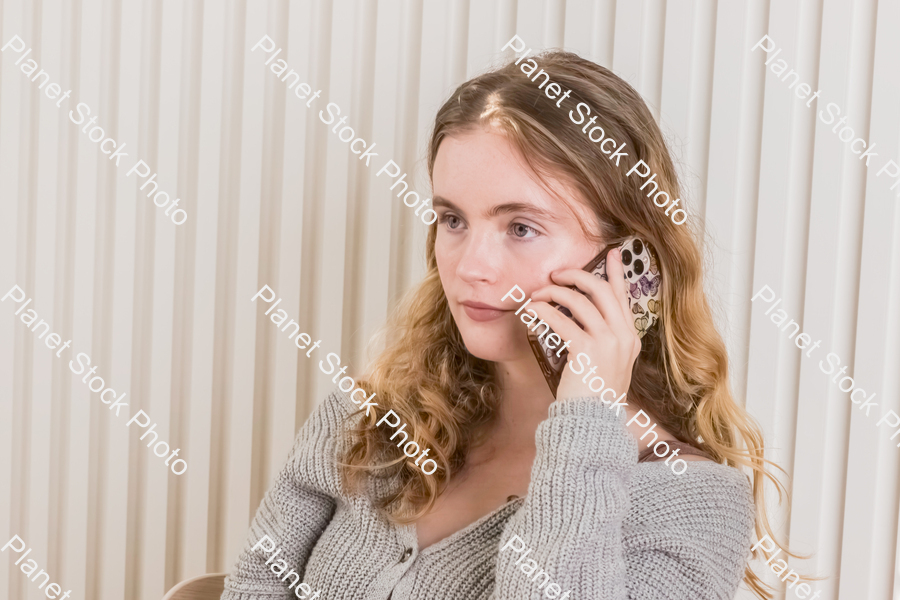 A girl sitting and using a mobile phone stock photo with image ID: 42f134c2-b6f2-4e3f-87b5-19b5d64d2bd5
