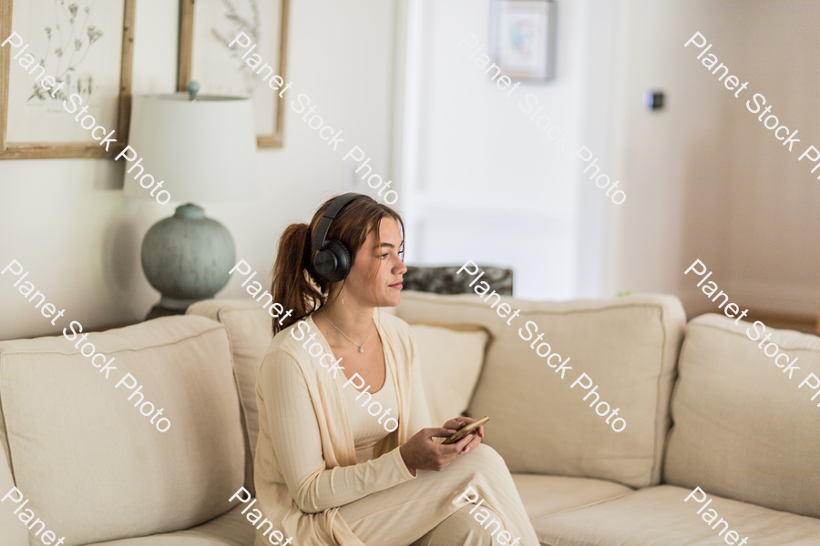 A young lady sitting on the couch stock photo with image ID: 4304638d-4da7-4d0e-a5c3-dd05d715f9f5
