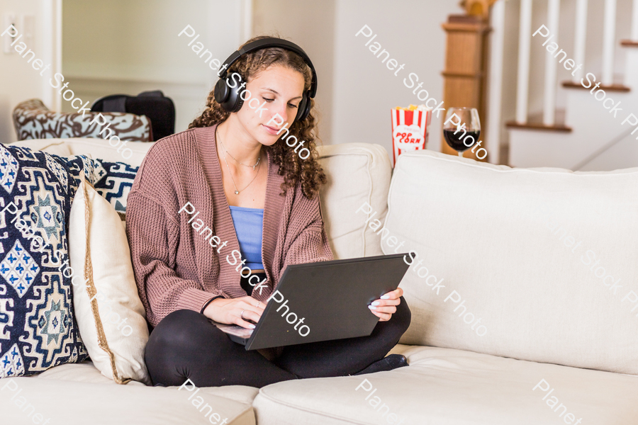 A young lady sitting on the couch stock photo with image ID: 4424b607-9057-4f6b-9add-52586feebacb