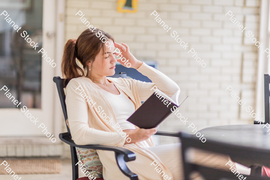 A young lady enjoying daylight at home stock photo with image ID: 44301e1a-2c1f-4953-94d2-cc5ef430a5e7