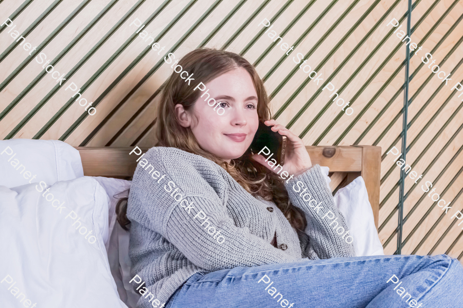 A girl in bed, using a mobile phone stock photo with image ID: 482c8d60-183e-48ab-a7fe-83fb55cc3d5d