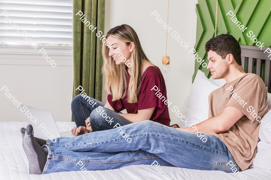 A young couple sitting in bed stock photo with image ID: 4aee0652-0bb7-4e61-8b5f-d0dabc4a8c26