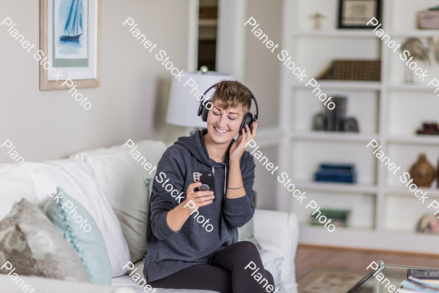 A young lady sitting on the couch stock photo with image ID: 4b0c1889-18f9-402d-9f12-4efd3efb05fc