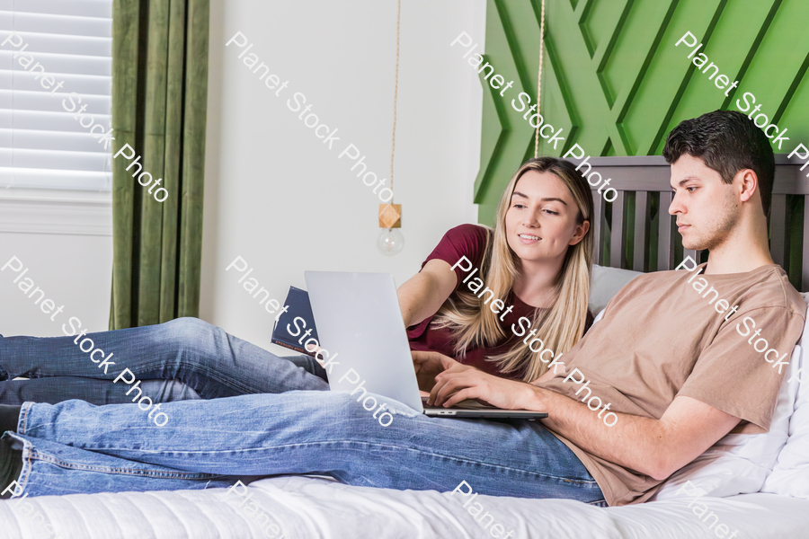 A young couple sitting in bed stock photo with image ID: 4b176be0-e5c9-4e60-8ff5-48ad3f12b615
