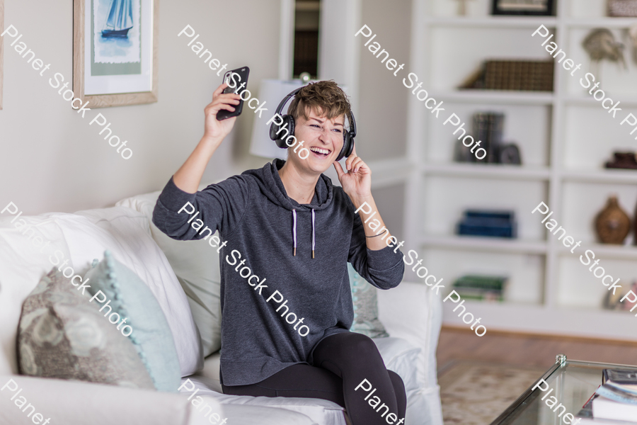 A young lady sitting on the couch stock photo with image ID: 4b5ff406-5ecc-4f8a-8539-16a0f515725e