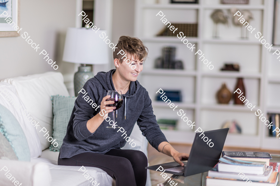 A young lady sitting on the couch stock photo with image ID: 4cea0143-6ad6-47d7-8692-3ed742386ad2
