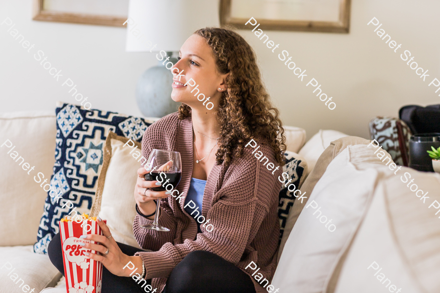A young lady sitting on the couch stock photo with image ID: 51e87c16-33e3-4bea-88f4-0501225bc785