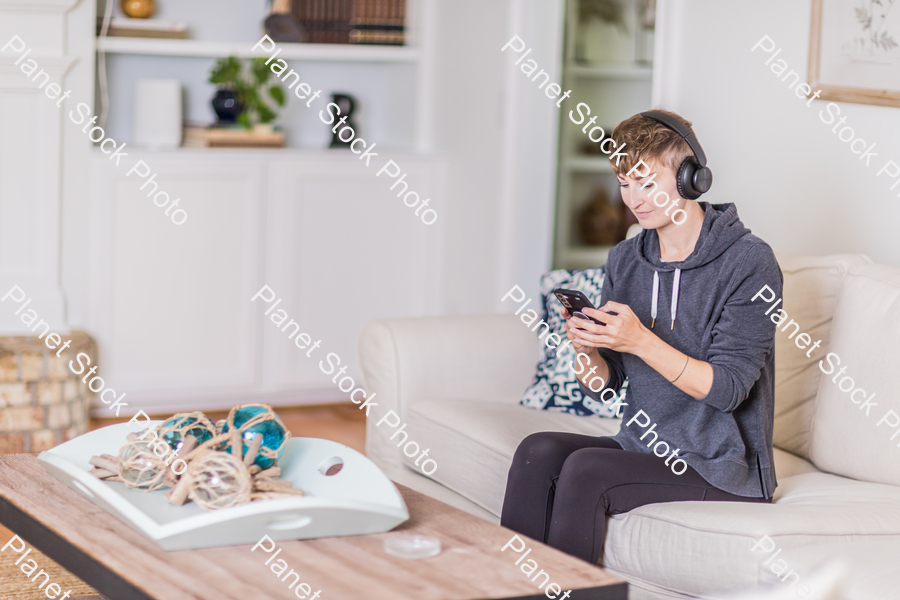 A young lady sitting on the couch stock photo with image ID: 54bc289c-1d81-4e0f-977f-98fc9ad04cc6