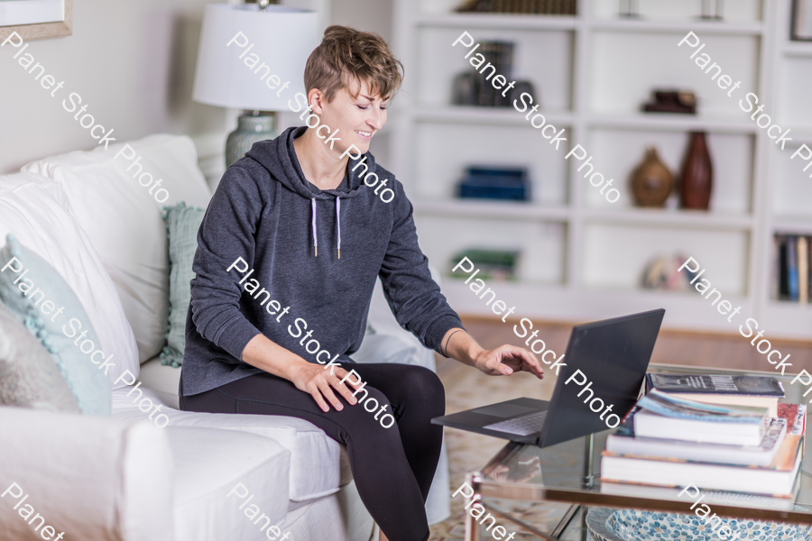 A young lady sitting on the couch stock photo with image ID: 5618fc33-517b-472a-8638-366a0f9d6ebb