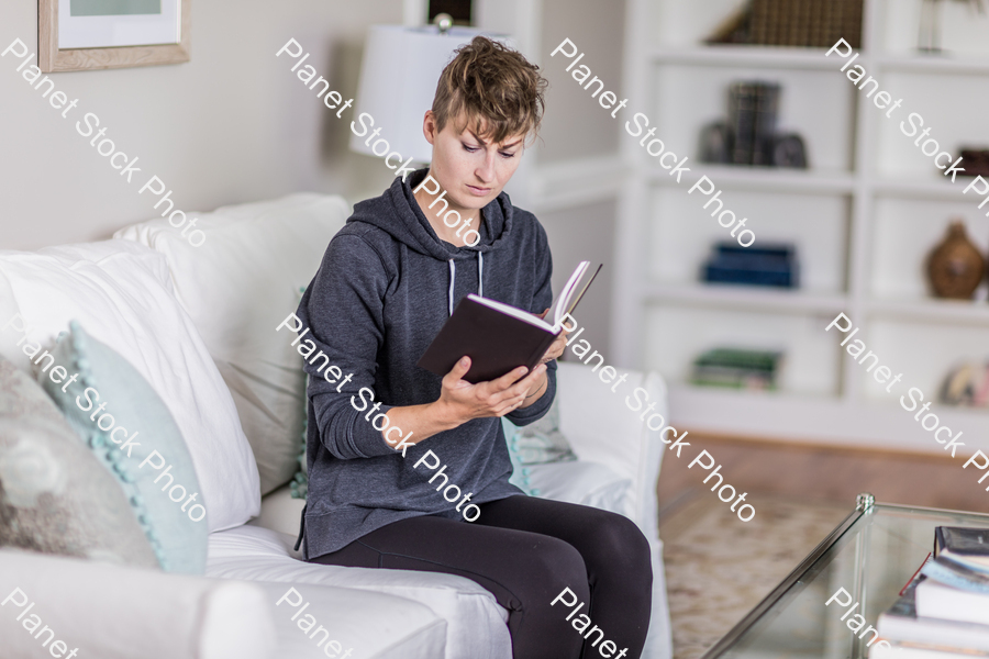 A young lady sitting on the couch stock photo with image ID: 5815d0e9-2376-4bf2-889d-cead5aceb848