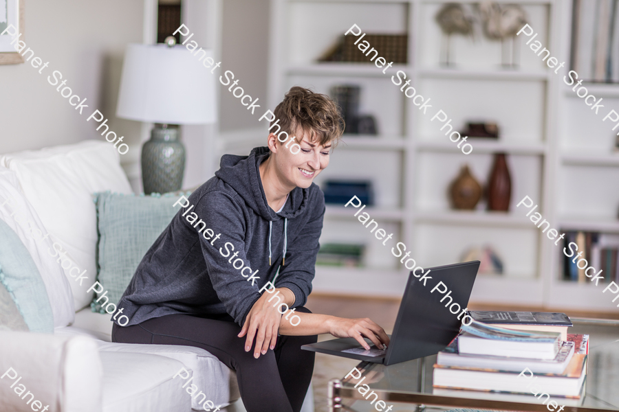 A young lady sitting on the couch stock photo with image ID: 590d7d53-4d7d-42b6-b998-19f04c1f7e74