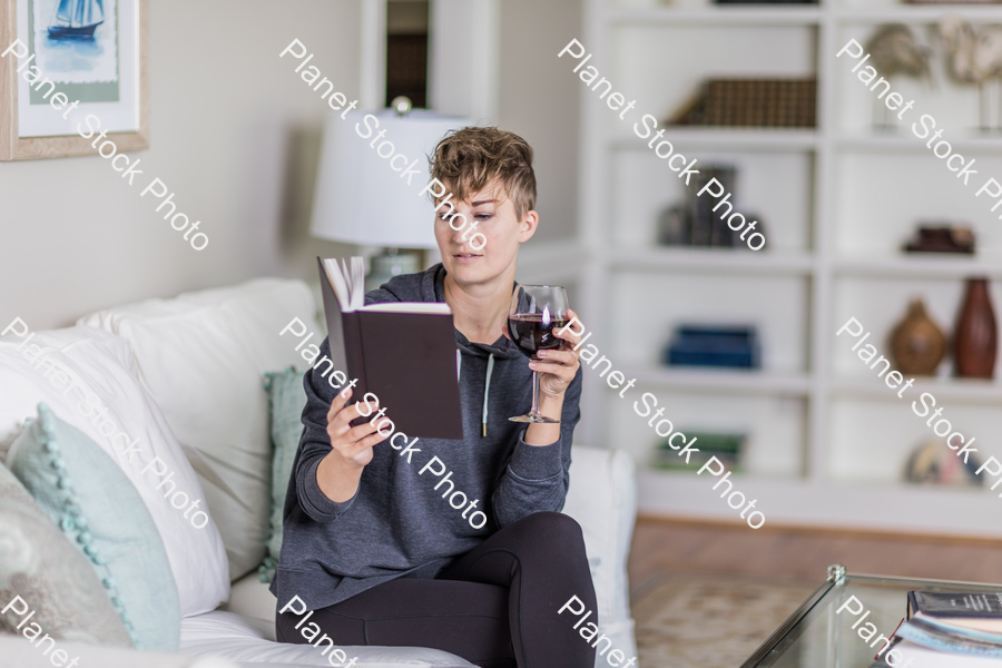 A young lady sitting on the couch stock photo with image ID: 59793551-c848-437f-ac60-1fd3686b179f