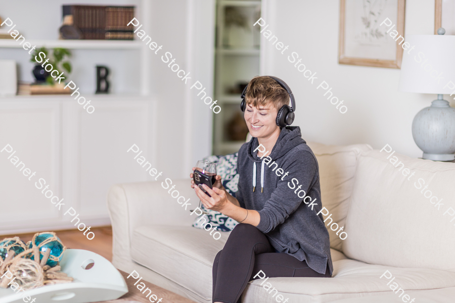 A young lady sitting on the couch stock photo with image ID: 5c5a43ce-48e1-4c83-801e-ea29809e49cd