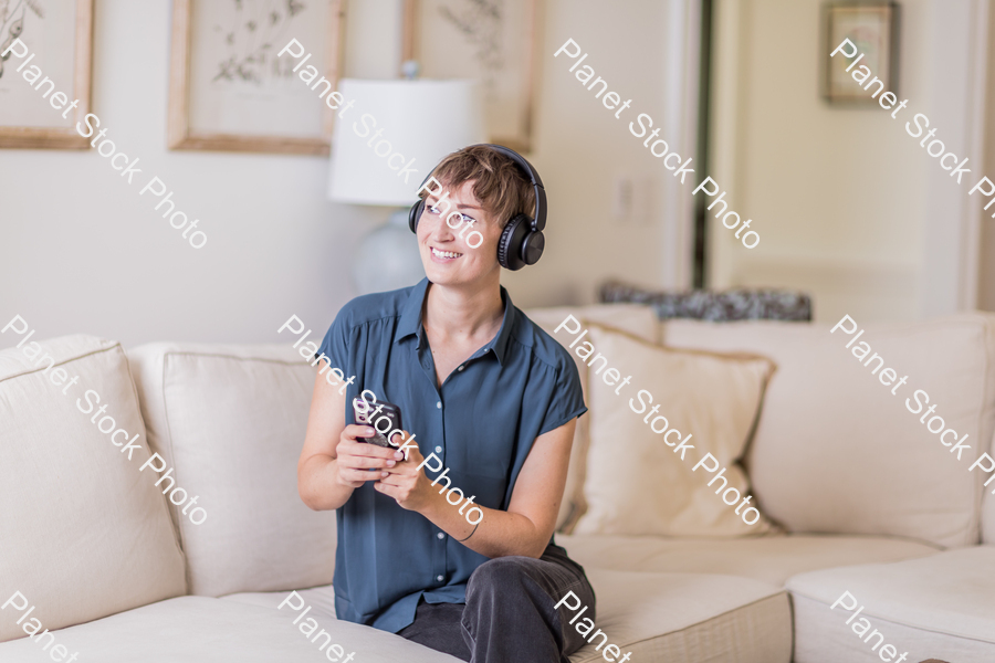 A young lady sitting on the couch stock photo with image ID: 5ccff1e9-a326-4ac8-89d8-3bfc31af9d22