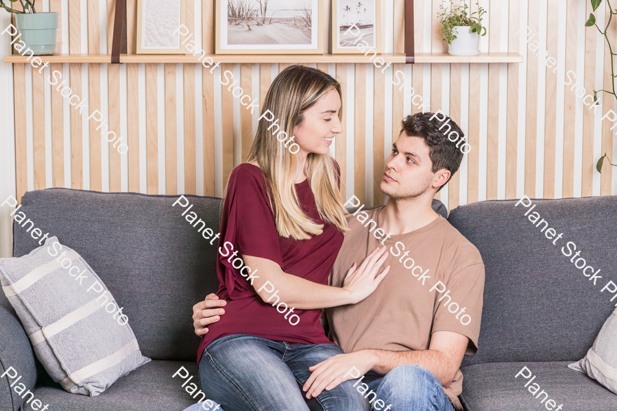A young couple cozying up on the couch stock photo with image ID: 5f1d6e15-17e0-4036-8219-ccfc0e6f390c