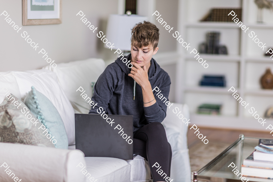 A young lady sitting on the couch stock photo with image ID: 5f545ba3-194f-45e1-a997-fbd8047d4469