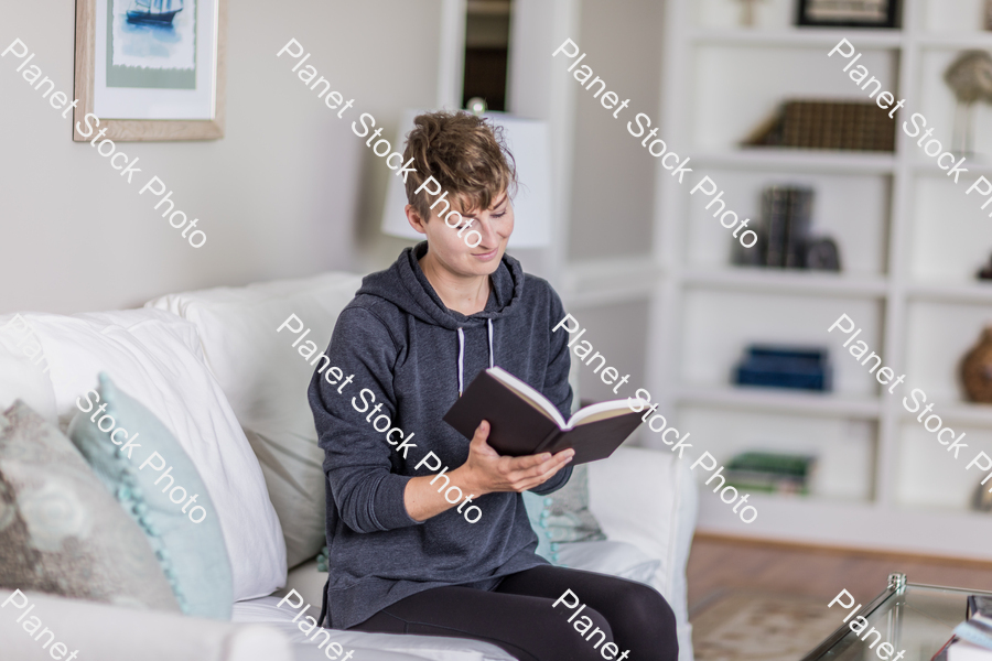 A young lady sitting on the couch stock photo with image ID: 5fe74e2c-0d0d-40f5-9965-66a07e7137c4