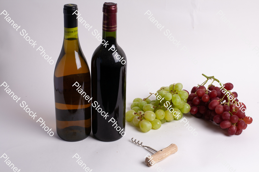 Two bottles of wine, with corkscrew, and grapes stock photo with image ID: 61b8fbac-d7e7-46f3-8729-7e01ce051028