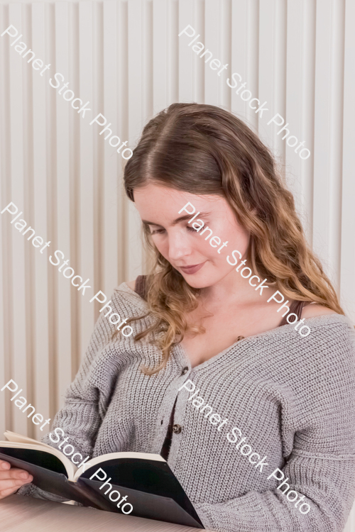 A girl sitting and reading a book stock photo with image ID: 632105f8-bec1-42a1-84db-c3082f632be6
