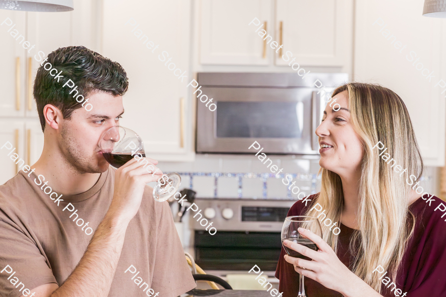 A young couple sitting and enjoying red wine stock photo with image ID: 63380ff3-4bfa-4c82-bfc6-0b8c52fe652e