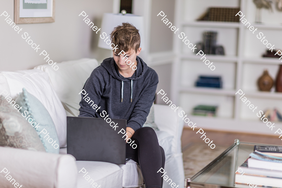 A young lady sitting on the couch stock photo with image ID: 63d04556-6dd3-4b2a-a483-58a6ceef036f