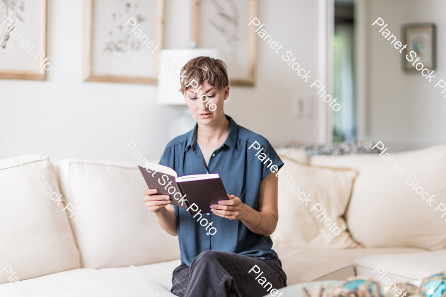 A young lady sitting on the couch stock photo with image ID: 63e172aa-a2ce-4950-9116-ccb7c90baed8